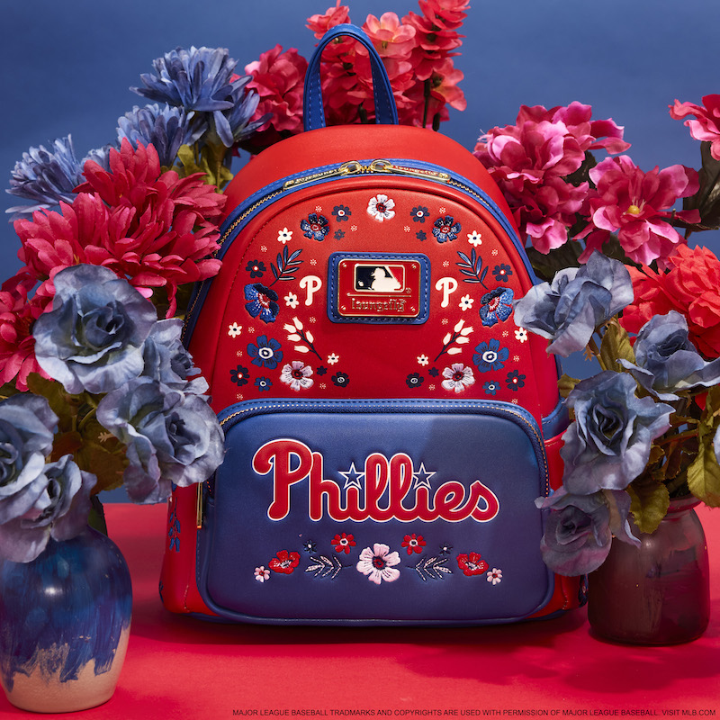 Red and blue floral Loungefly Philadelphia Phillies mini backpack against a red and blue background surrounded by red and blue flowers 
